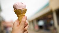 strawberry ice cream melting on a cone